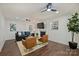 A well-lit living room features hardwood floors, a modern ceiling fan, and comfortable seating around a fireplace at 3165 Pendleton Ave, Charlotte, NC 28210