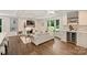 Cozy living room featuring hardwood floors, a stone fireplace, a comfortable sofa, and large windows providing natural light and views at 3165 Pendleton Ave, Charlotte, NC 28210