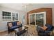 Cozy sunroom with brick accent wall, sliding glass doors, and comfortable wicker furniture with a view of the outdoors at 3165 Pendleton Ave, Charlotte, NC 28210