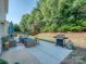 Landscaped backyard with patio seating, outdoor grill, and lush greenery at 3511 Dominion Green Dr, Charlotte, NC 28269