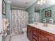 Cozy bathroom with a cherry wood vanity, shower with a patterned curtain, and ceramic tile flooring at 3511 Dominion Green Dr, Charlotte, NC 28269