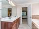 Bathroom vanity with double sinks, tile flooring, and tub with tiled surround at 3511 Dominion Green Dr, Charlotte, NC 28269