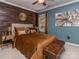 Stylish bedroom with wood accent wall, modern art, and a plush brown quilted bedspread at 3511 Dominion Green Dr, Charlotte, NC 28269