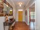 Inviting foyer with hardwood floors, decorative mirror, and a bright yellow door at 3511 Dominion Green Dr, Charlotte, NC 28269
