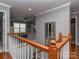 Upstairs hallway with hardwood floors, wood railing, and a view of the living area at 3511 Dominion Green Dr, Charlotte, NC 28269