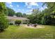 Spacious backyard featuring a stone fire pit area with seating and a lush green lawn at 4017 Sulkirk Rd, Charlotte, NC 28210