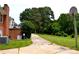 A brick house exterior with a spacious backyard and a partial view of the driveway at 405 Wesley Heights Dr, Albemarle, NC 28001
