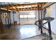 A storage basement, features exposed ceilings, a treadmill, and a large door to the exterior at 405 Wesley Heights Dr, Albemarle, NC 28001