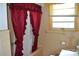Bathroom featuring patterned curtains, window with blinds, and basic fixtures giving a simple charm at 405 Wesley Heights Dr, Albemarle, NC 28001