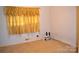 This bedroom features a window with yellow curtains, wall outlet, and shelf with sound equipment at 405 Wesley Heights Dr, Albemarle, NC 28001