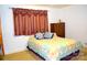Cozy bedroom with wood dresser, patterned bedspread, and decorative curtains, offering a comfortable and inviting space at 405 Wesley Heights Dr, Albemarle, NC 28001