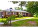 Charming one-story brick home featuring a well-maintained lawn and mature trees at 405 Wesley Heights Dr, Albemarle, NC 28001