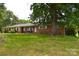 Traditional brick home with a large tree in the front yard and manicured landscaping at 405 Wesley Heights Dr, Albemarle, NC 28001