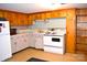 A vintage kitchen featuring upper cabinets and a classic white stove and refrigerator at 405 Wesley Heights Dr, Albemarle, NC 28001