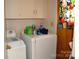 Laundry room area with white washer and dryer and overhead storage at 405 Wesley Heights Dr, Albemarle, NC 28001