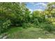 The serene backyard features lush greenery, trees, and grassy areas providing a peaceful outdoor space at 408 Orange St, Shelby, NC 28150