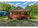 View of the home with a front porch and mature trees in the background at 408 Orange St, Shelby, NC 28150