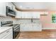 Bright kitchen with white cabinets, stainless steel appliances, and polka dot backsplash at 408 Orange St, Shelby, NC 28150