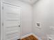 A laundry room features wood look floors and a white door with a place for the washer and dryer hookups at 408 Orange St, Shelby, NC 28150