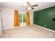 Cozy bedroom featuring a ceiling fan, accent wall, window with curtains and plush carpeting at 506 Broadway Ct, Statesville, NC 28677