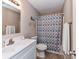 Bathroom with white vanity, mirror, patterned shower curtain and tiled floors at 5105 Hampton Meadows Rd, Monroe, NC 28110