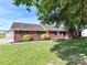 Red brick ranch style house with well manicured lawn and a detached garage at 5105 Hampton Meadows Rd, Monroe, NC 28110