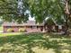 Inviting brick home with a lush, green lawn and mature trees at 5105 Hampton Meadows Rd, Monroe, NC 28110