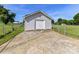A detached garage with white door and matching siding, set in a fenced yard at 5105 Hampton Meadows Rd, Monroe, NC 28110