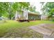 A fenced backyard with a wooden deck, grass, and a concrete area at 5424 Amado St, Charlotte, NC 28215