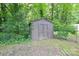 A backyard storage shed surrounded by grass and foliage at 5424 Amado St, Charlotte, NC 28215