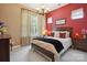 This bedroom features a stylish chandelier, neutral carpets, and an eye-catching red accent wall at 5524 Elk Knob Ct, Denver, NC 28037