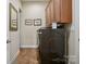 A well-kept laundry room features a front-load washer and dryer and upper cabinets at 5524 Elk Knob Ct, Denver, NC 28037