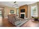 Well-lit living room with hardwood floors, fireplace, and modern lighting fixture at 5524 Elk Knob Ct, Denver, NC 28037