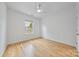 Bright bedroom with hardwood floors, a ceiling fan, and a large window providing ample natural light at 5728 Mantario Dr, Charlotte, NC 28269