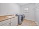 Bright laundry room with a sink, countertop, cabinets, and modern washer and dryer at 5728 Mantario Dr, Charlotte, NC 28269