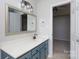 Bathroom vanity with a decorative mirror and lighting fixture, and doorway into a bedroom at 5806 Autumn Trace Ln, Indian Trail, NC 28079
