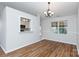 Bright dining room featuring hardwood floors, a modern chandelier, and natural light at 5806 Autumn Trace Ln, Indian Trail, NC 28079