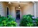 Inviting front porch with hanging light fixture and beautiful green landscaping at 5806 Autumn Trace Ln, Indian Trail, NC 28079