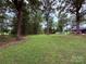 Spacious backyard with mature trees offering shade and privacy at 605 Impala Dr, Albemarle, NC 28001