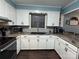 Modern kitchen with white cabinets, granite countertops, and stainless steel appliances at 605 Impala Dr, Albemarle, NC 28001