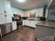 Well-lit kitchen features white cabinets, stainless steel appliances, and a granite countertop at 605 Impala Dr, Albemarle, NC 28001