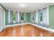 Bedroom with hardwood floors and natural light streaming through multiple large windows at 6206 Hunter Ave, Charlotte, NC 28262