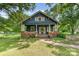 Charming blue home with inviting front porch and brick accents, surrounded by lush greenery at 6206 Hunter Ave, Charlotte, NC 28262