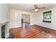 Bright living room with original hardwood floors, a fireplace, and doorway to another room at 6206 Hunter Ave, Charlotte, NC 28262