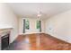 Open living area featuring hardwood floors, a fireplace, and a ceiling fan for comfort at 6206 Hunter Ave, Charlotte, NC 28262