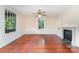 Bright living room with hardwood floors, fireplace, and abundant natural light from the large windows at 6206 Hunter Ave, Charlotte, NC 28262