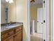 This half-bath offers a wood cabinet and granite countertop, conveniently located in-home at 6565 Robin Hollow Dr, Mint Hill, NC 28227