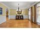 Elegant dining room with hardwood floors, decorative chandelier, and large windows with natural light at 6565 Robin Hollow Dr, Mint Hill, NC 28227