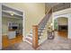 Elegant foyer with staircase, decorative railing, and views into an adjacent office and living room at 6565 Robin Hollow Dr, Mint Hill, NC 28227