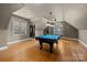 Spacious game room features a pool table, hardwood floors, recessed lighting, and bright windows at 6565 Robin Hollow Dr, Mint Hill, NC 28227